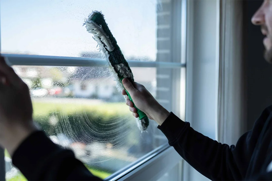 Einwaschen einer Glasscheibe mit einem professionellen Fensterwischer