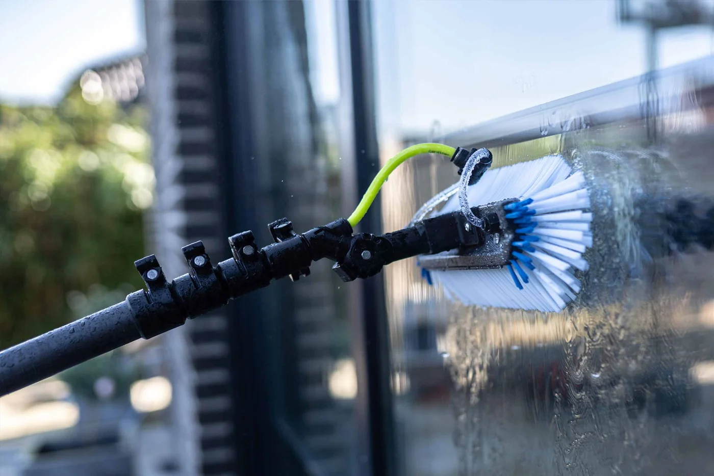 Reinstwasser-Bürste im Einsatz an einer Glasfläche.